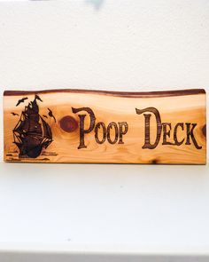 a wooden sign that says pop deck with a pirate ship on the front and bottom