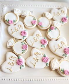 some decorated cookies are arranged on a white surface with pink and gold trimmings