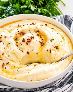 a bowl filled with mashed potatoes and garnished with parsley