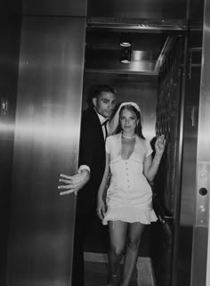 black and white photograph of man and woman in elevator