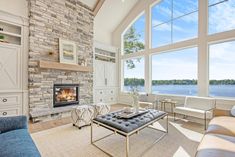 a living room filled with furniture and a fire place in front of a large window