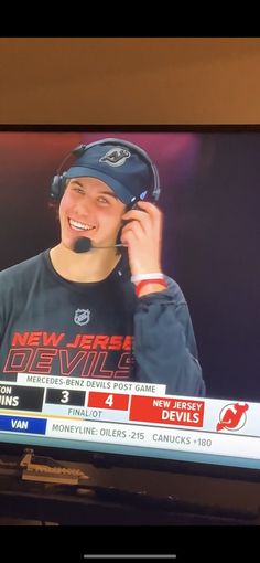 a television screen with a news anchor on it's face talking on the phone