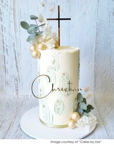 a white cake with gold decorations and a cross on top