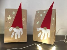 two brown bags with red and white paper hats on them, one has an image of a unicorn