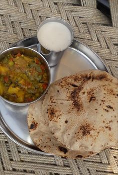 a silver plate topped with food next to a cup of milk