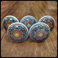 four decorative knobs on a wooden surface