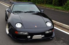 a black sports car is parked on the side of the road