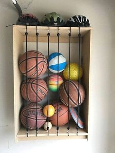 a shelf with basketballs and other sports balls in it