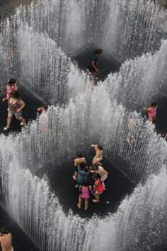 several people are playing in the water fountain