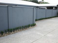 a grey building with plants growing out of it