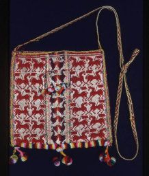 a red and white bag with tassels hanging from it's side on a black background