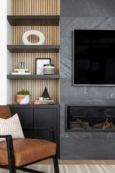 a living room with a fireplace and television mounted on it's wall above a brown leather chair