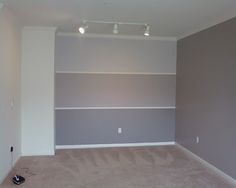 an empty living room with no furniture in the house or office space, but is painted gray and white