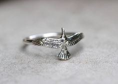 This listing is for one sterling silver thunderbird stacking ring. I love the detail of these majestic hawk rings and feel connected to all of the birds of prey that I love so much when I wear it. It features one detailed sterling silver hawk fired onto a 14 gauge sterling silver ring band. This delicate hawk even has cute little feet on the inside. Wear this bohemian ring to show your affinity and love for all things natural, spiritual, and sky-bound. It is a powerful and eye-catching piece. St Silver Bird Ring, The Birds Of Prey, Bird Ring, Jeweled Bag, Silver Ring Band, Bird Rings, Eagle Ring, Bohemian Ring, Silver Eagle