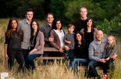 a group of people posing for a family photo in the middle of some tall grass