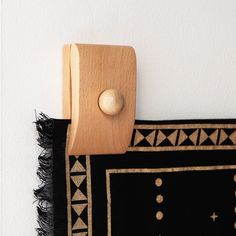 a black and white rug with a wooden hook on it