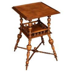 an antique wooden table with turned legs and a shelf on the top for storing items