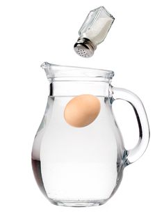 a glass pitcher with an egg in it