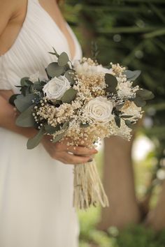 a woman holding a bouquet of flowers in her hands