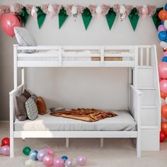 a white bunk bed sitting next to a bunch of balloons