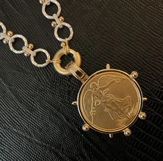 a gold necklace with a coin on it