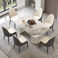 a dining table with chairs around it and a bowl of fruit on the table top