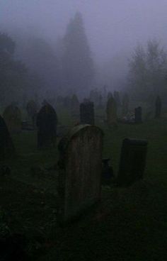 an old cemetery in the fog with headstones and tombstones on it's sides