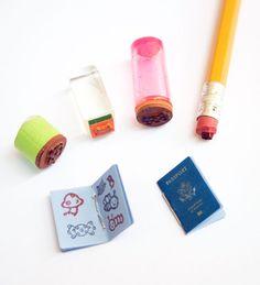 several small objects are arranged on a white surface, including a passport, pencil and eraser