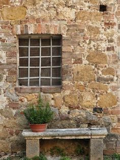 an old stone building with a bench and window