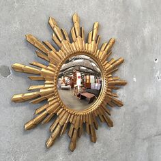 a gold sun shaped mirror on the wall