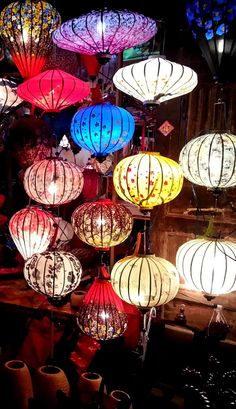 many colorful lanterns are hanging from the ceiling