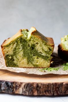 a piece of green cake sitting on top of a wooden cutting board