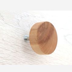 a wooden door knob on a white wood surface