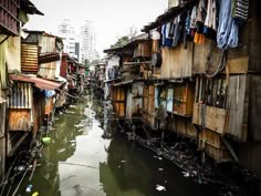 an alley way with clothes hanging out to dry in the water and buildings on either side