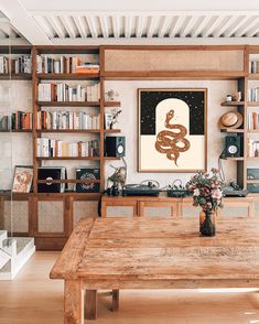 a wooden table sitting in front of a book shelf filled with books