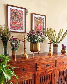 there are many vases with flowers on top of the dresser next to each other