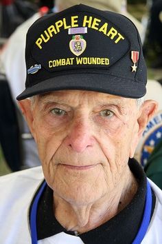 an older man wearing a purple heart hat