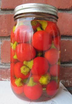 a jar filled with lots of red and yellow tomatoes