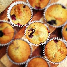 several blueberry muffins sitting on top of a wooden cutting board