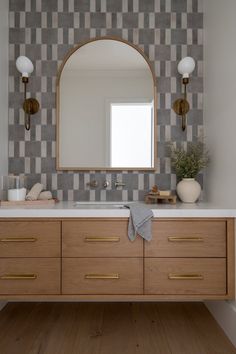 a bathroom vanity with a mirror, sink and two lights on the wall above it