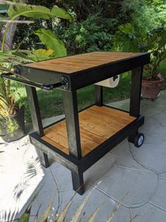 a small cart sitting on top of a cement ground next to some bushes and trees