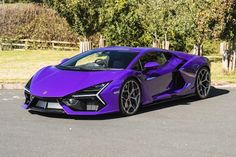 a purple sports car is parked on the street