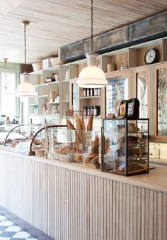 a counter with many items on it in a room that has lots of shelves and windows