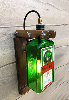 a green bottle hanging from a hook on a wooden wall