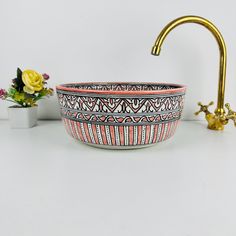 a sink and faucet with flowers in the background