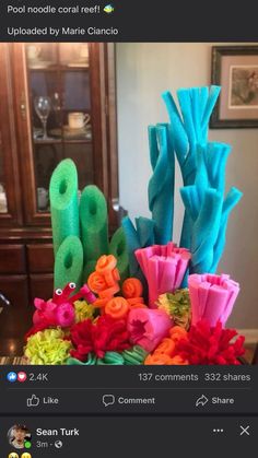 an arrangement of fake flowers in a vase on a table