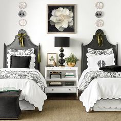 two beds with black and white bedding in a bedroom next to a nightstand table