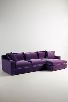 a purple couch sitting on top of a white floor