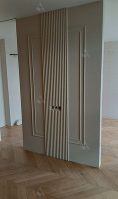 an empty room with wooden flooring and white painted doors on the wall, in front of a parquet wood floor