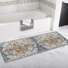 a bath tub sitting next to a rug in a bathroom